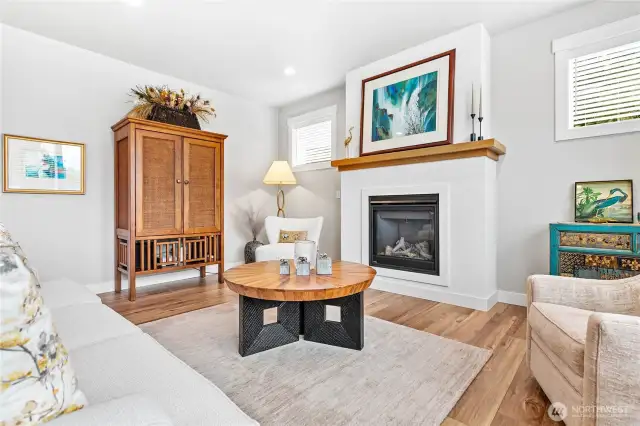 Cozy gas fireplace elegantly complete with stucco finish & warm wood mantel