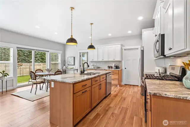 Large well-appointed kitchen w/gorgeous wood base cabinets, granite counters, full tile backsplash, & stainless steel appliances