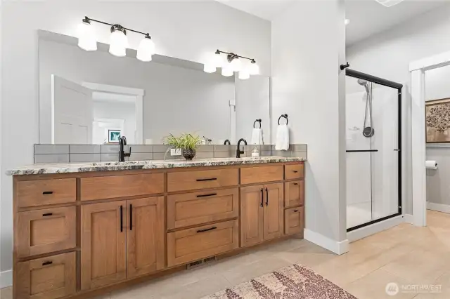 Ensuite bathroom w/beautiful wood cabinets & nice neutral tile; separate commode room & door to huge walk-in closet to right of pic