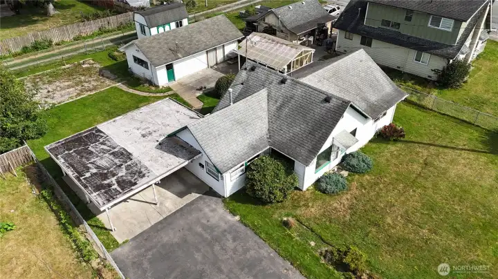 Aerial capturing home,greenhouse, detached workshop, and shed