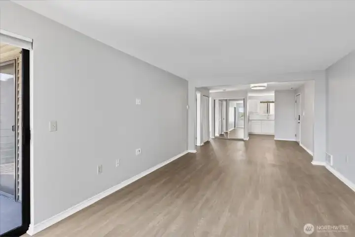 Enjoy vinyl plank flooring throughout the condo.    This picture is looking back from living room to dining room and to kitchen.