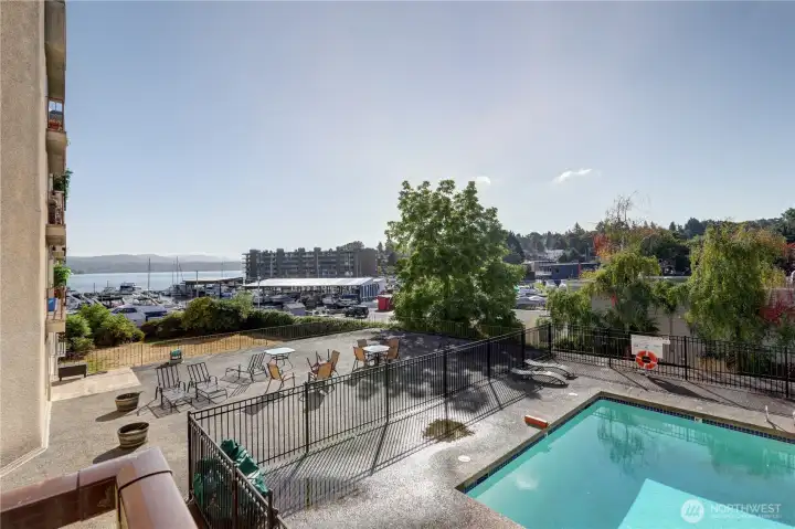 View from the deck with fenced in pool and large patio area for relaxing in the sun.
