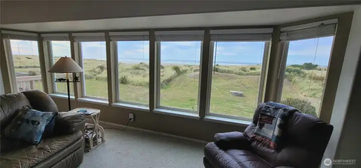 Wall of windows overlooking the deck, beach and Pacific ocean