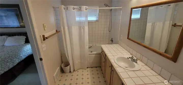 Ensuite bathroom with tile counters and jetted tub.