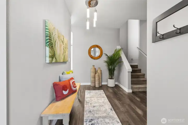Wide plank hardwood floors in a rich, multi-tone grain pull you in immediately, paired with crisp white trim and a soft whisper-gray palette that keeps everything feeling fresh and elevated. The 9-foot ceilings hit right away, giving the space that open, expansive feel that just reads expensive. Stairs rise cleanly to the upper bonus level, while a full bath and coat storage sit thoughtfully in the background. It’s bright, composed, and sets the tone. Wide plank hardwood floors in a rich, multi-tone grain pull you in immediately, paired with crisp white trim and a soft whisper-gray palette that keeps everything feeling fresh and elevated. The 9-foot ceilings hit right away, giving the space that open, expansive feel that just reads expensive. Stairs rise cleanly to the upper bonus level, while a full bath and coat storage sit thoughtfully in the background. It’s bright, composed, and sets the tone.