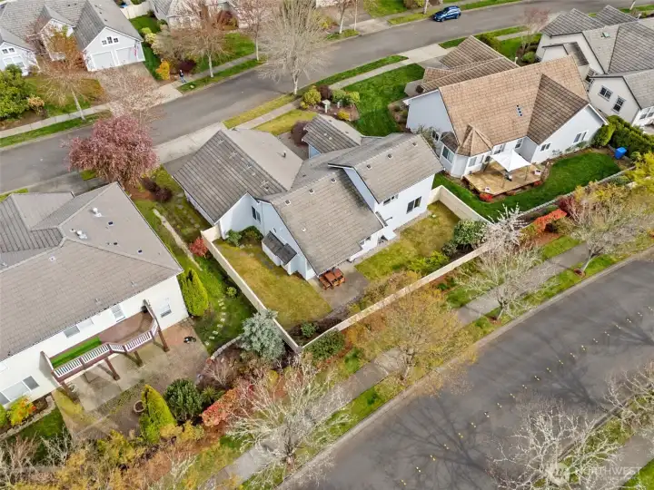 The tile roof takes center stage, looking crisp and beautifully maintained, with that dimensional texture that instantly elevates the entire home. It’s the kind of detail that reads even better from above. And then there’s the positioning. With no direct neighbors behind, the home backs to a neighborhood road, creating a surprising sense of openness and privacy in the backyard. It’s a subtle advantage that makes a noticeable difference, giving the outdoor space a quieter, more tucked-away feel without sacrificing connection to the neighborhood.