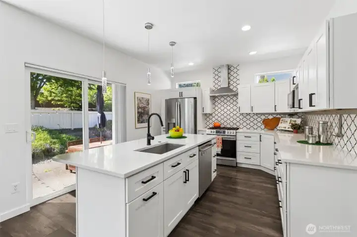 You’re looking straight across the island to that big sliding glass door, pulling in natural light and giving you an easy connection out to the patio. The matte black touch faucet is a little bit of a power move, sleek, modern, and just plain fun to use, paired with matching hardware on crisp white shaker cabinetry that keeps everything grounded and classic. And then there’s the backsplash, running all the way to the ceiling in a subtle Moroccan-inspired pattern that adds texture without overwhelming the space. Three low-profile pendant lights hover over the island, fully dimmable so you can shift the mood whenever you want. Stainless appliances are all included, and with the recent updates, this kitchen feels fresh. You’re looking straight across the island to that big sliding glass door, pulling in natural light and giving you an easy connection out to the patio. The matte black touch faucet is a little bit of a power move, sleek, modern, and just plain fun to use, paired with matching hardware on crisp white shaker cabinetry that keeps everything grounded and classic. And then there’s the backsplash, running all the way to the ceiling in a subtle Moroccan-inspired pattern that adds texture without overwhelming the space. Three low-profile pendant lights hover over the island, fully dimmable so you can shift the mood whenever you want. Stainless appliances are all included, and with the recent updates, this kitchen feels fresh.
