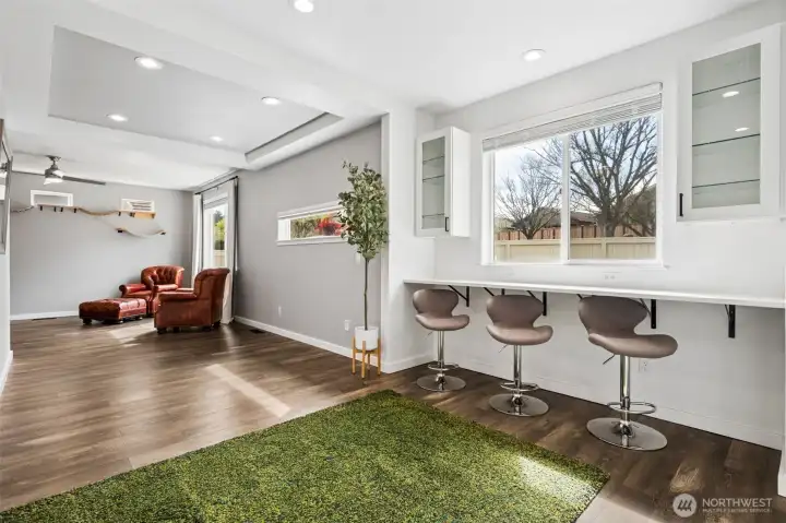 This spot is quietly stealing the show. A full built-in breakfast bar tucked under the window with three stools in place, and room to squeeze in a fourth or fifth when the crowd inevitably expands. And yes, all the stools stay, because this house understands the assignment. Morning coffee, laptops open, someone scrolling, someone chatting, it all happens right here. The glass front cabinets are ready for your prettiest pieces.