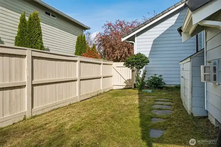 A clean paver walkway guides you right to the gate and around to the front, making the whole property feel connected and intentional. The solid fencing gives you that extra layer of privacy, creating a tucked-away zone that feels separate from the main yard. Garden beds, a dog run, a little outdoor project area, it’s all on the table here.