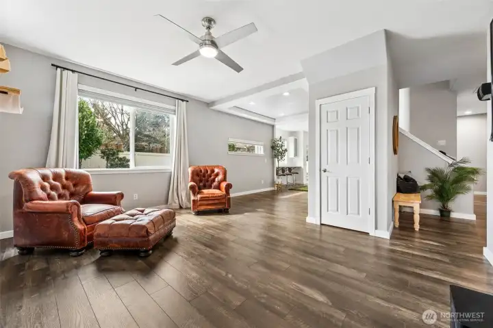 Light pours in through the large backyard window, carrying across the living space and into the dining area, where that high horizontal window does something very smart, it brings in sunlight while leaving your walls fully usable for a buffet, console, or whatever you need. The staircase is right there, leading up to the oversized bonus room, adding that extra layer of flexibility to the home’s 2,157 square feet.