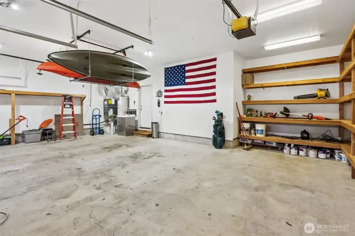 The ceiling height opens things up in a big way, giving you room to get kayaks, paddle boards, or all the golf gear up and out of the way without sacrificing floor space. Built-in wood shelving is already in place, solid, practical, and ready to handle real storage, not just the lightweight stuff. And the lighting is bright enough that if one bay turns into a workshop, hobby zone, or weekend project headquarters, it actually works. The garage utility sink is an added bonus making project clean up easy!