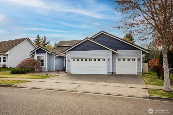 Wide, clean access to the garage with two automatic doors, both topped with windows that bring in natural light while keeping the interior private. So yes, your garage gets daylight, but no one’s getting a tour from the driveway. The lines are sharp, the layout is functional, and everything feels intentional. Step back and you’ve got a neighborhood that delivers too, miles of level sidewalks for walking, running, or evening laps, plus extra street parking that makes hosting simple instead of stressful.