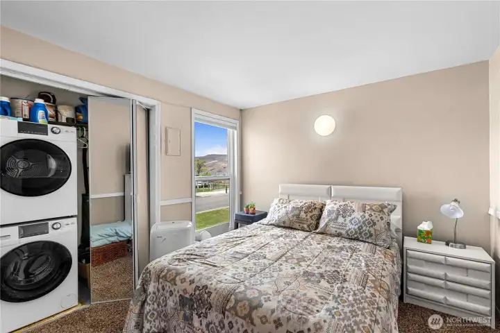 Washer/dryer in primary bedroom with a queen bed Washer/dryer in primary bedroom with a queen bed