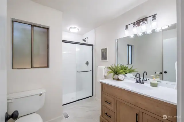 Main floor guest bathroom recently remodeled with new tile, shower, flooring, lighting and vanity.