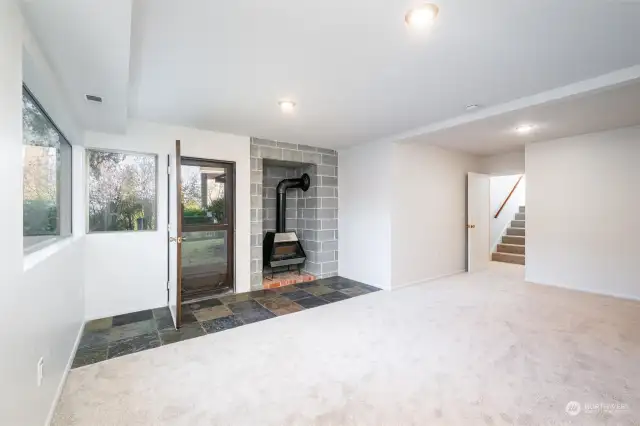 Family room with a door to the yard and a classic wood stove.