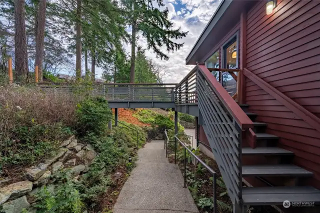 Steps to kitchen door, deck & bridge to the dog run.