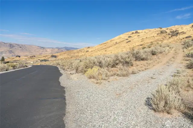 Looking North from the maintained, paved road. Driveway to the property is on the right.