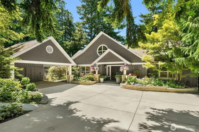 A one of a kind custom home! A gorgeous exterior with generous paved driveway, and extensive landscaping. The home is perfectly framed by the trees. Architect was Dan Nelson of Designs Northwest.