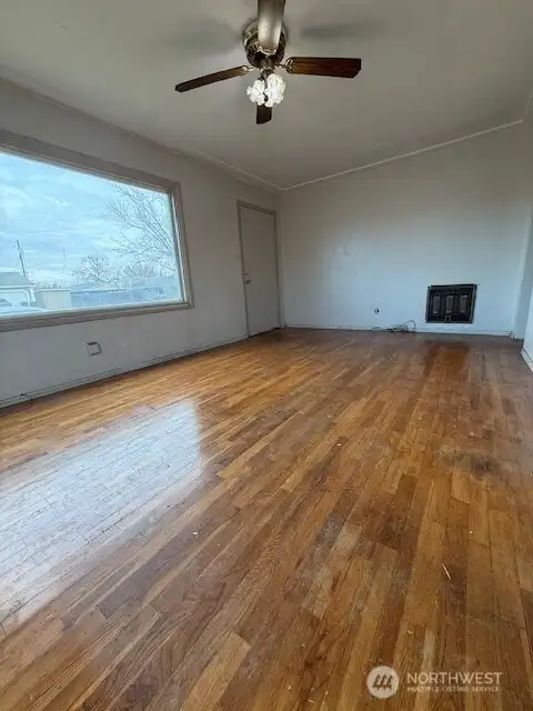 Good size living room includes original hardwood.  Imagine an electric fireplace added against the wall to  also add an excellent focal point for this space.