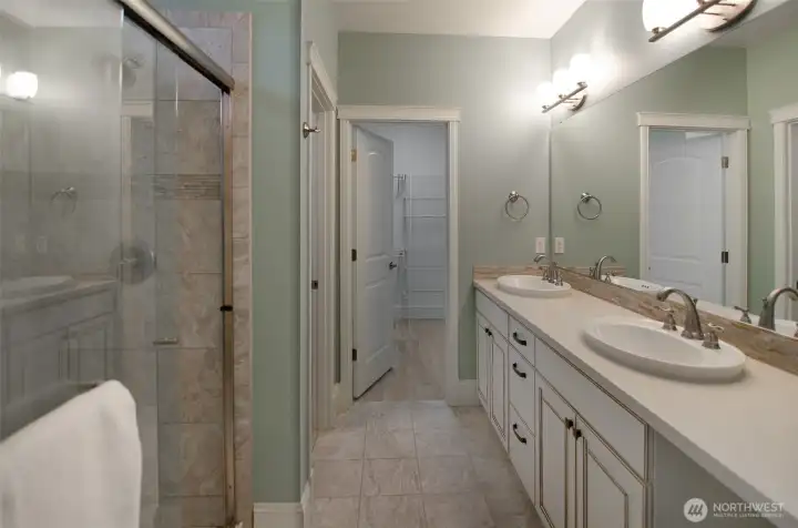 Luxury primary bath with expanded tiled shower, double sinks, private toilet area and ample walk-in closet.