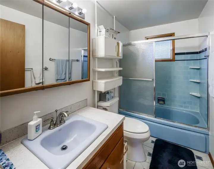 Full bath with retro blue tub/surround.