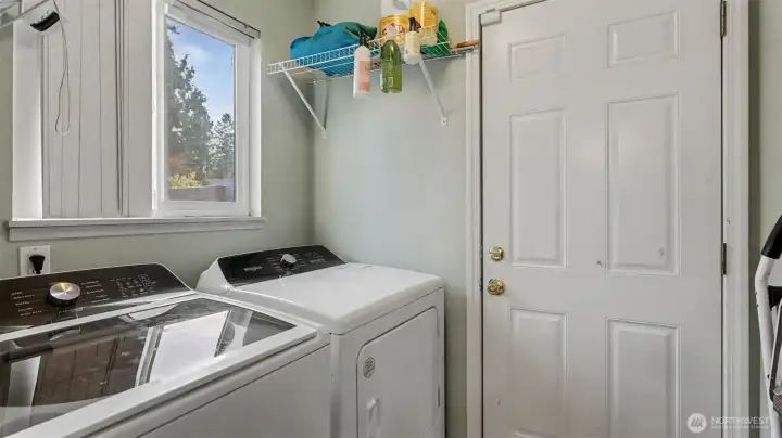 Bright laundry area with window and shelving for storage