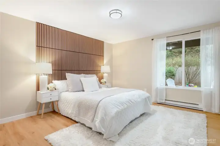 Spacious primary suite with wood slat accent wall.