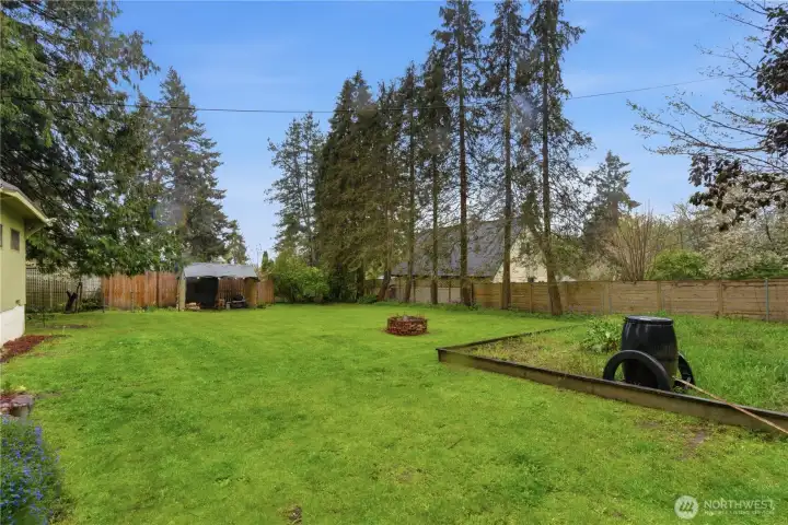 Another view of the spacious backyard highlights the generous outdoor area, offering plenty of room to garden, play, or simply relax and enjoy the setting.