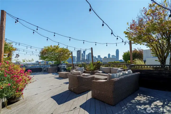 Rooftop deck with seating, grills, and city views