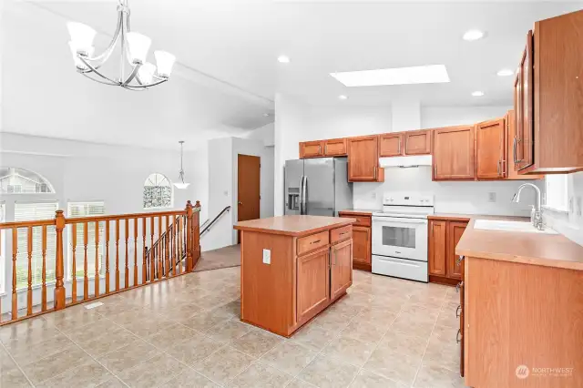 Kitchen view looking toward the hallway and stairs leading down to the living room and lower level