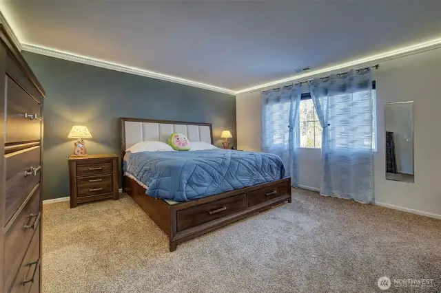 Spacious primary bedroom with smart lighting around perimeter.