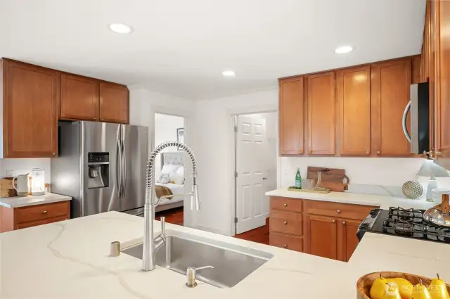 Spacious kitchen with new quartz countertops and ceiling height cabinets.