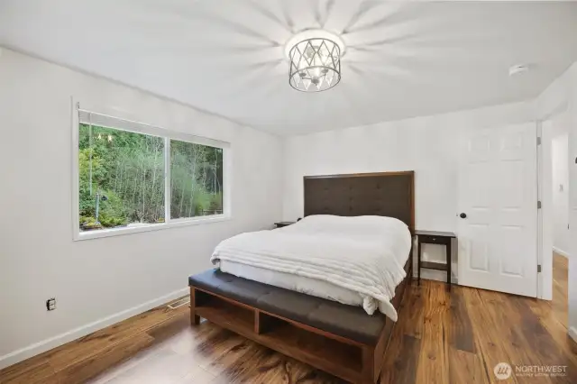 Primary bedroom with tranquil backyard view.