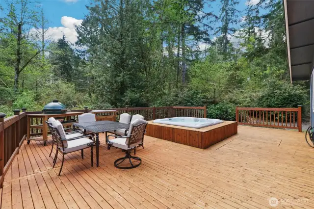 Wrap around deck with Jacuzzi hot tub. Features multiple seating areas.