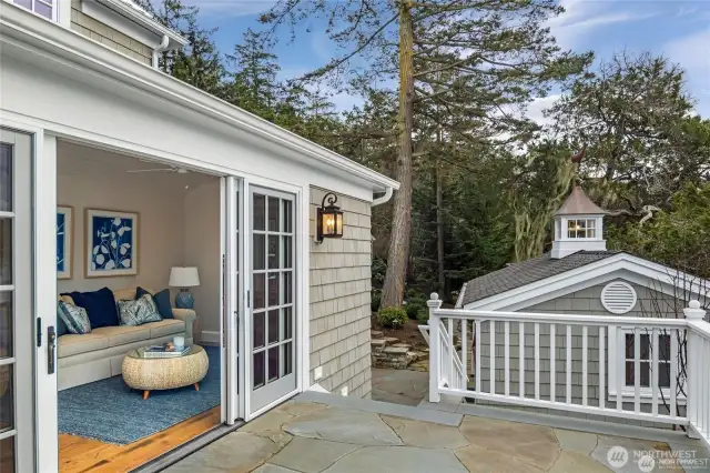 Downstairs bedroom opens onto a sunny deck with boat house in the background.