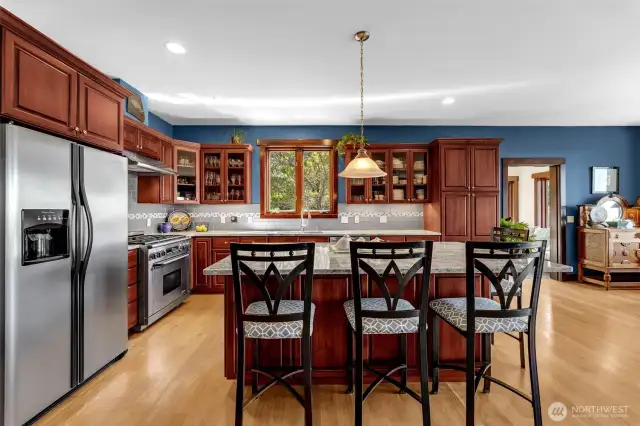 Cooks kitchen! Dacor range, stainless Frigidaire, glass fronted upper cabinets, pull out drawers throughout, expansive granite island and counters, glass subway tile