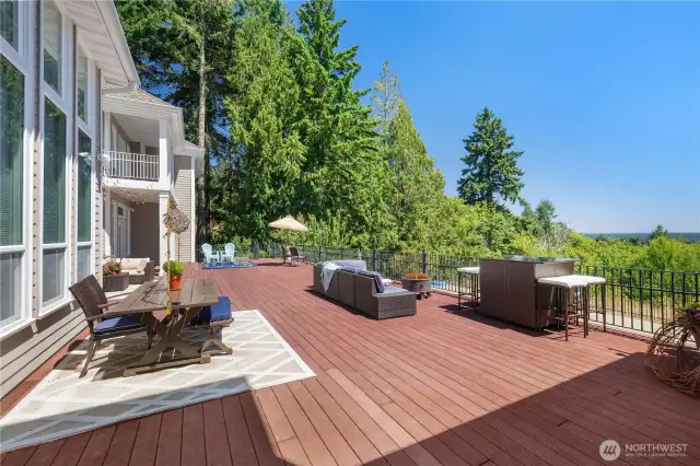 2100 sq ft deck with built-in hot tub and fire pit. Deck overlooks patio and in-ground heated pool.