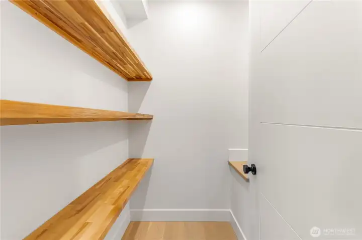 Walk-in pantry with custom shelves. To the right is a larger than you would expect nook.
