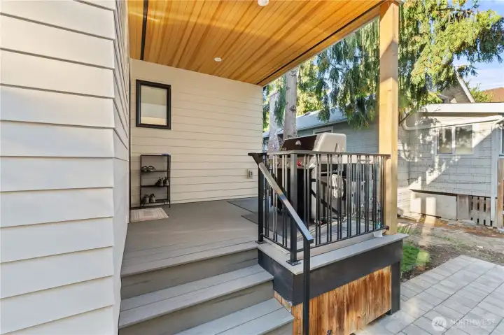 Covered deck right off the kitchen. A few extra touches you might not notice at first glance: cedar ceiling above, gas plumbing for the BBQ, to the right below the railing is a custom door to access under the porch storage.
