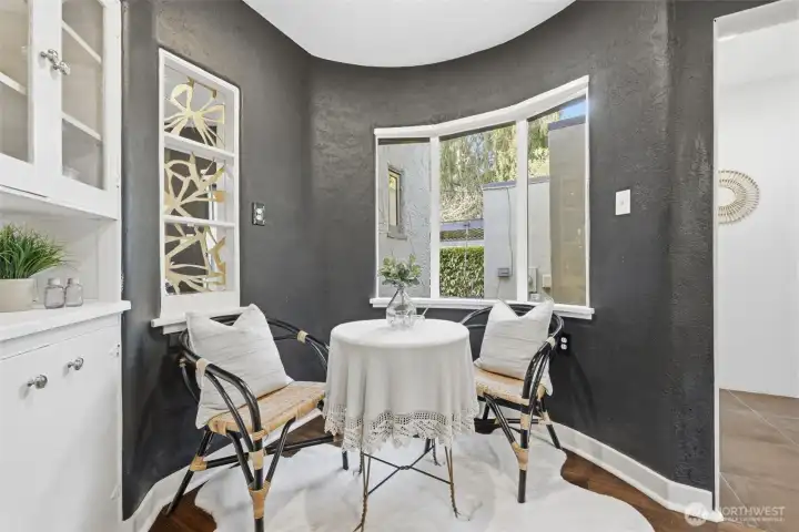 The curved wall encompasses a charming breakfast nook. The metal sculptures in the window are a custom design. There is so much charm in this home!
