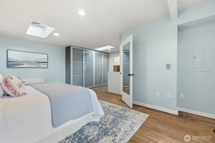 The frosted glass sliding doors seen in the center enclose your custom built closet. The mirrored door opens to your bathroom.