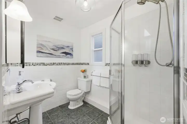 Your en-suite bathroom has a shower stall and pedestal sink.