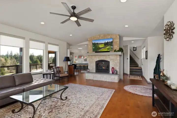 Living room with gas fireplace looks into kitchen. Front door to the right.