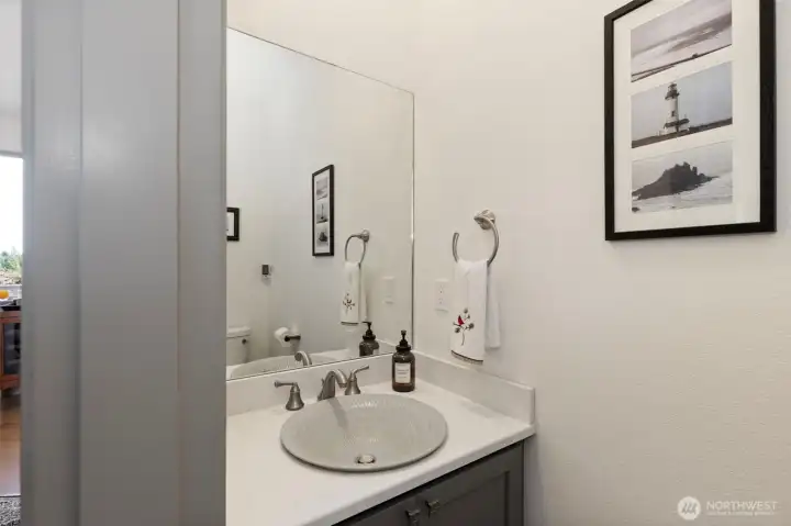 Downstairs half bath located between kitchen and stairs.