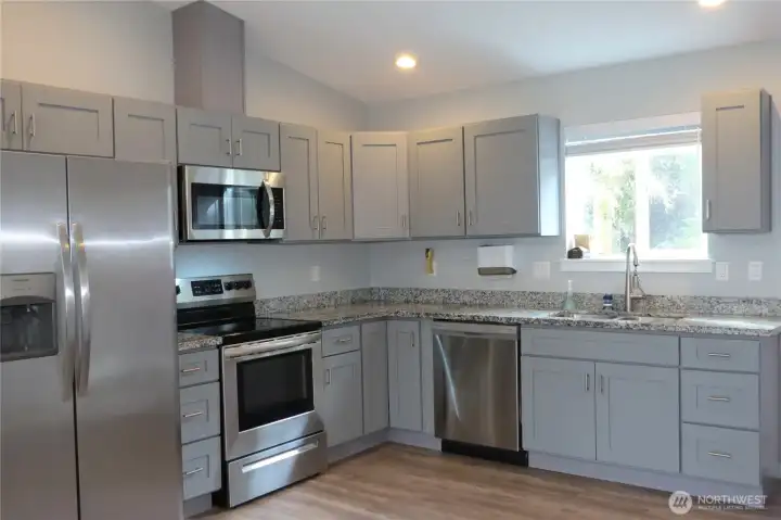 KITCHEN BOASTS EASY CLOSE CABINETRY AND QUARTZ COUNTERTOPS!