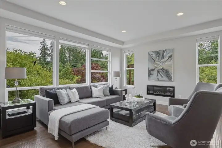 Off the entryway is this living room drenched in natural light with floor-to-ceiling windows all around.