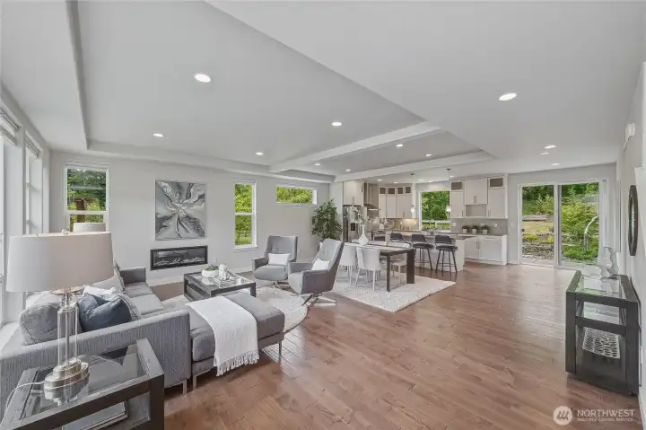 Looking toward the back sliding door, you see the full open layout, with lots of lighting, a dining area and breakfast bar in the kitchen.