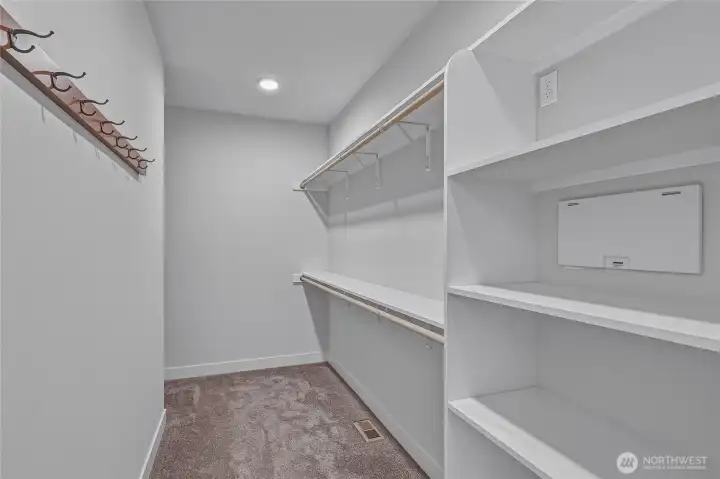 Primary suite closet has built in shelving.
