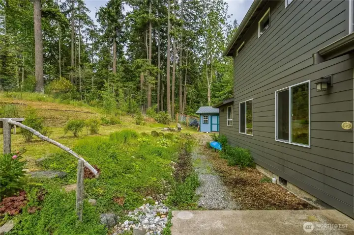 Looking along the back of the house: to the left is terraced gardens, and a garden shed in the distance.