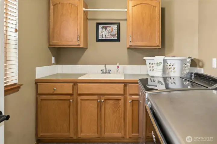 Upstairs laundry and utility room with deep utility sink and built in cabinets